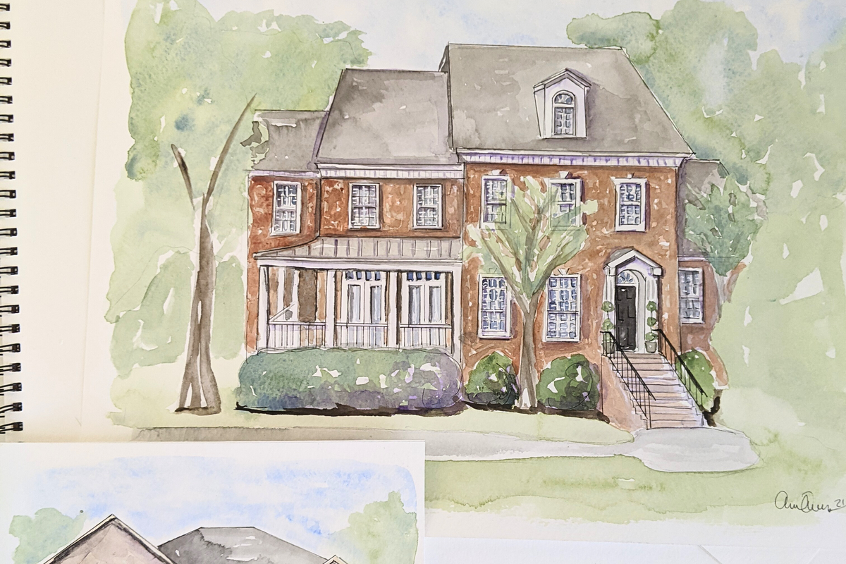 Watercolor illustration of a two-story house with trees and a garden on a spiral-bound notebook.